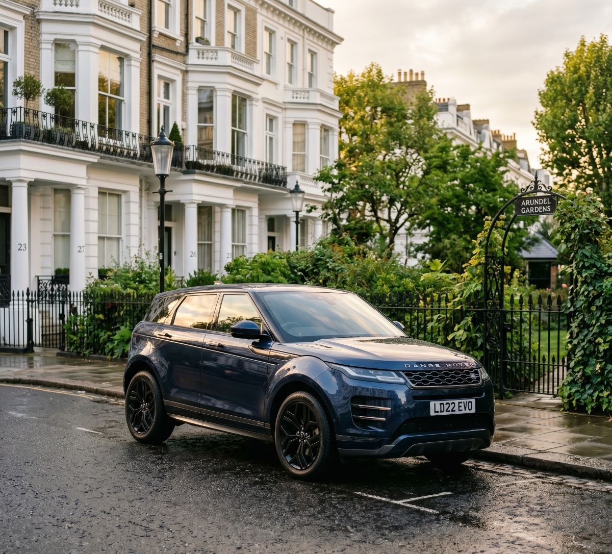 a navy blue Range Rover Evoque parked along the wrought-iron fence beside Arundel Gardens in Kensington, London